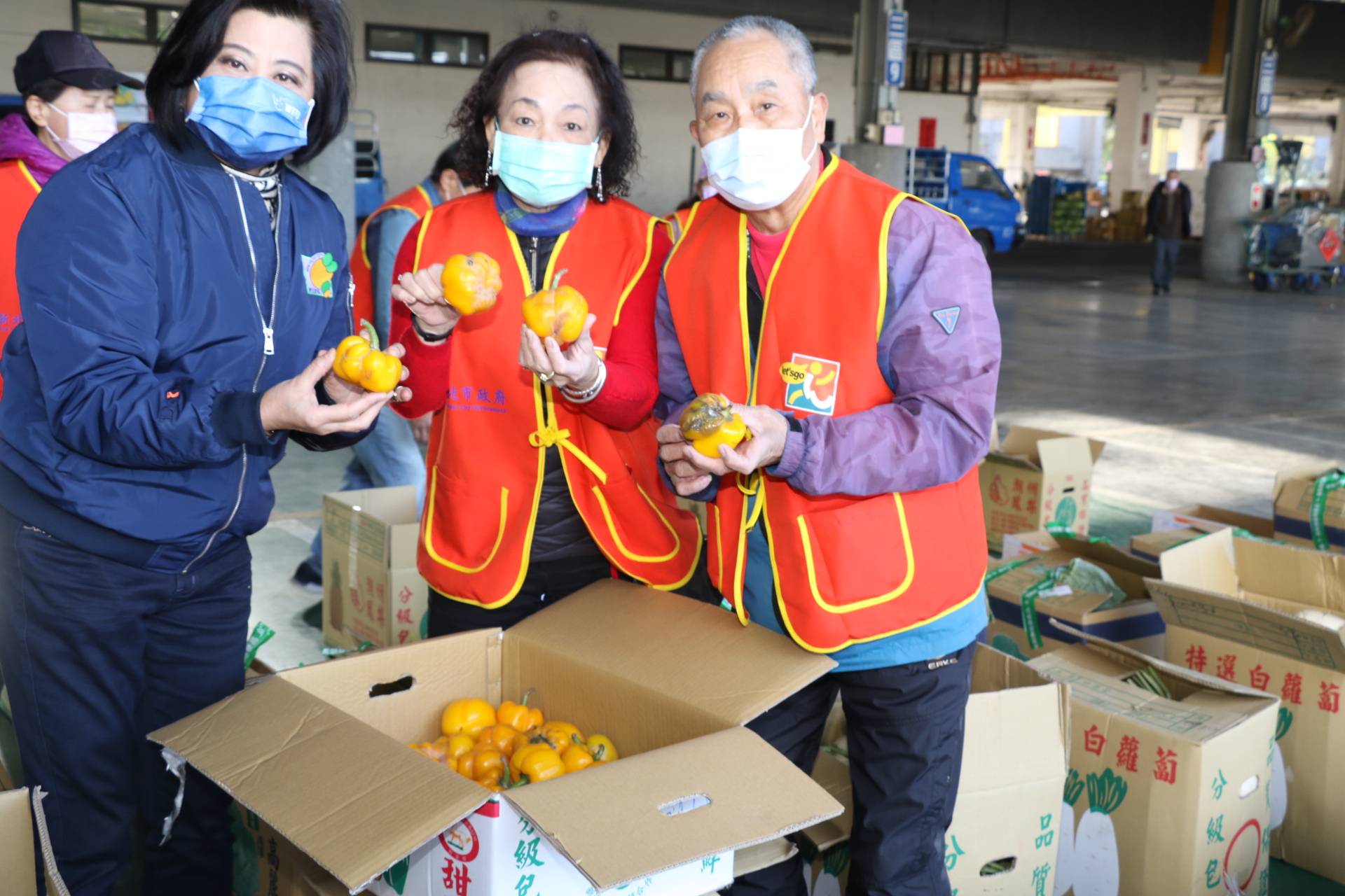 新北市果菜運銷公司總經理江惠貞（左）和理菜志工挑揀出一些較不佳的黃椒  這些有點爛掉的蔬菜不會送到據點